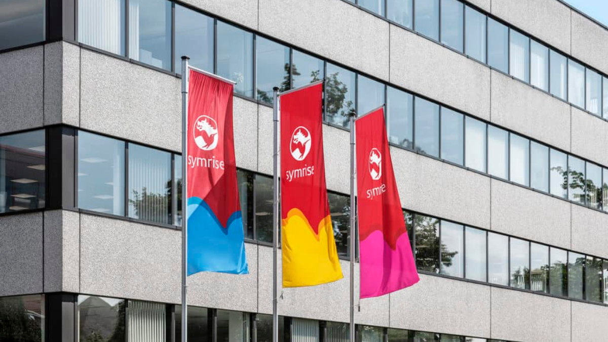 Symrise headquarters with branded flags displayed outside the company building.